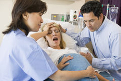 分娩台の上で出産する妊婦の画像