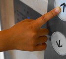 エレベーターのボタンを押す指の画像